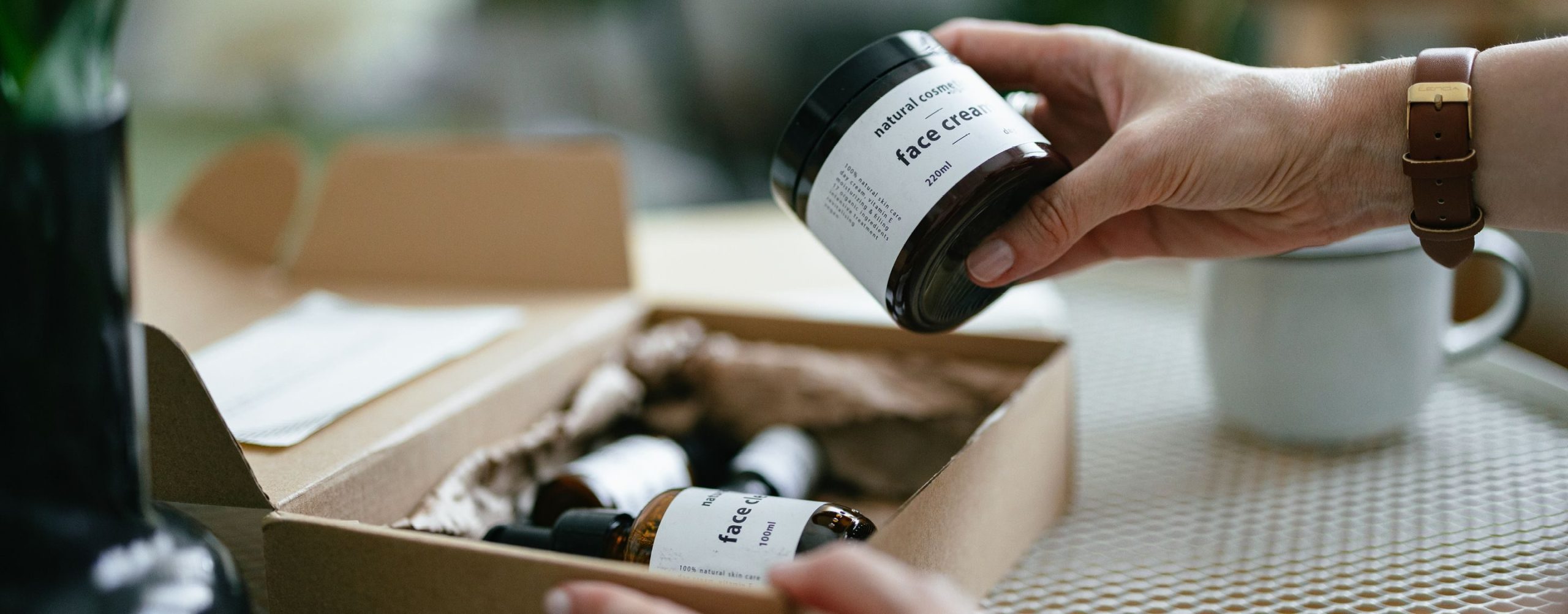 Hands unpacking a box of branded consumer products