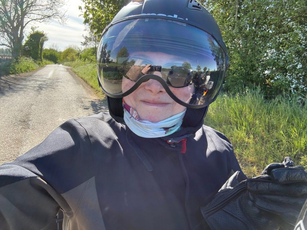Riding in a motorcycle helmet on an English country lane