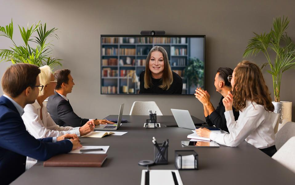 Attorney on a video call with a conference room of professionals